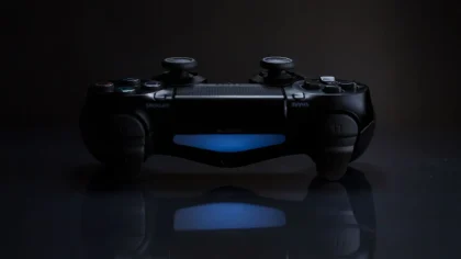 Manos sosteniendo un controlador de videojuegos con símbolos de descuento y precios digitales de fondo