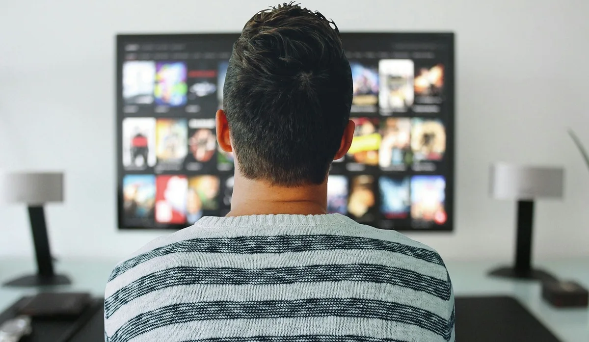 Fire TV Stick conectado a un televisor moderno con control remoto en primer plano