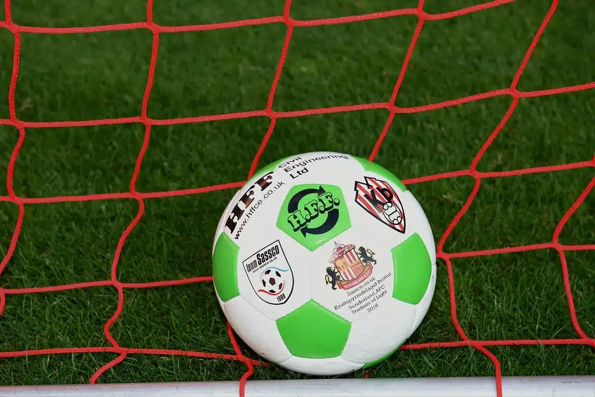 Jugador de fútbol en acción en un campo con luces de estadio de fondo
