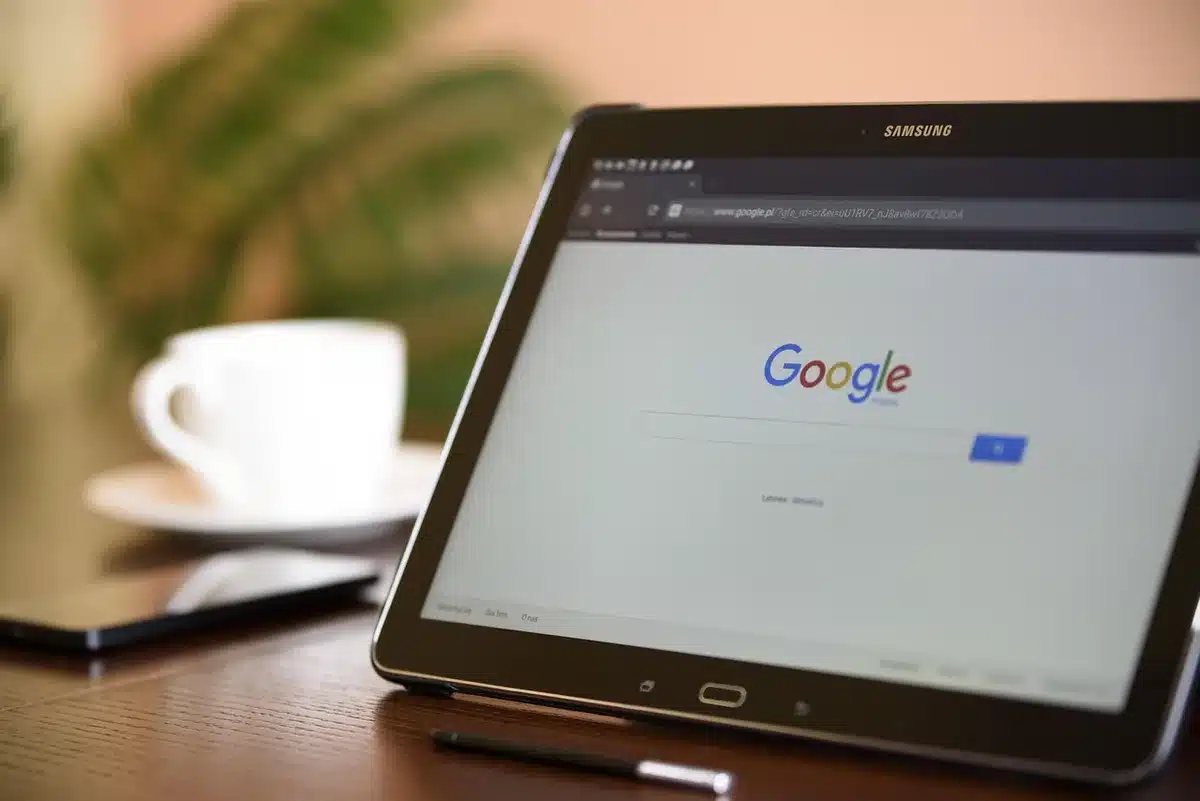 Manos anónimas sobre un portátil con un tablero tipo Buscaminas reflejado en la pantalla