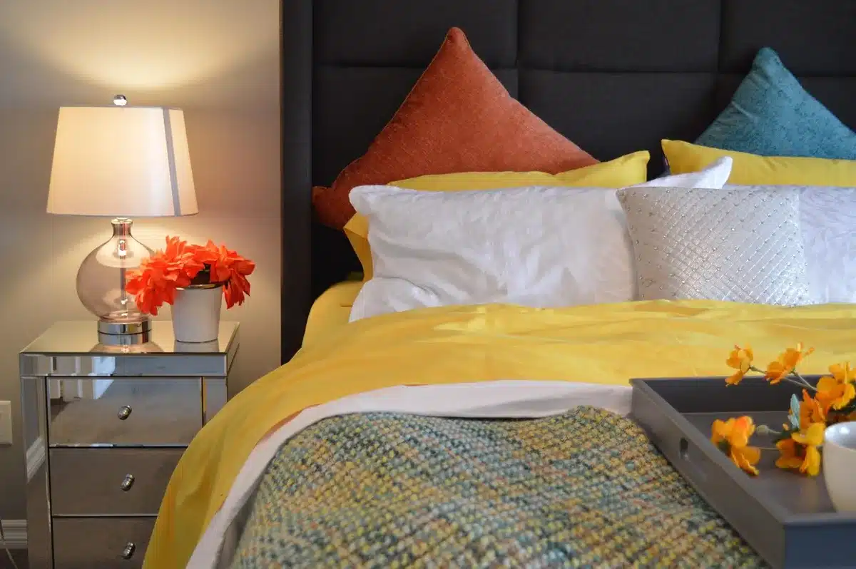 small bedside lamp on a nightstand emitting warm progressive glow, anonymous bedroom setting