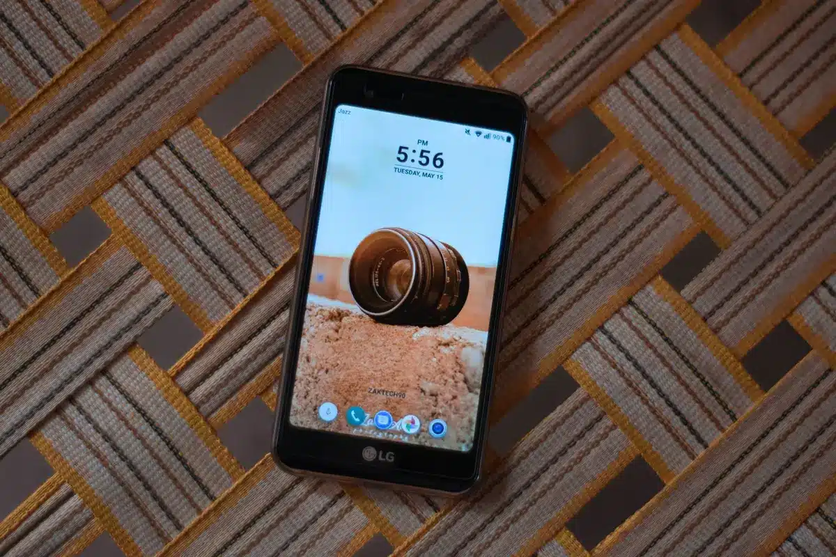 Empty modern smartphone on a wooden table showing a generic video player interface; no brands or logos visible