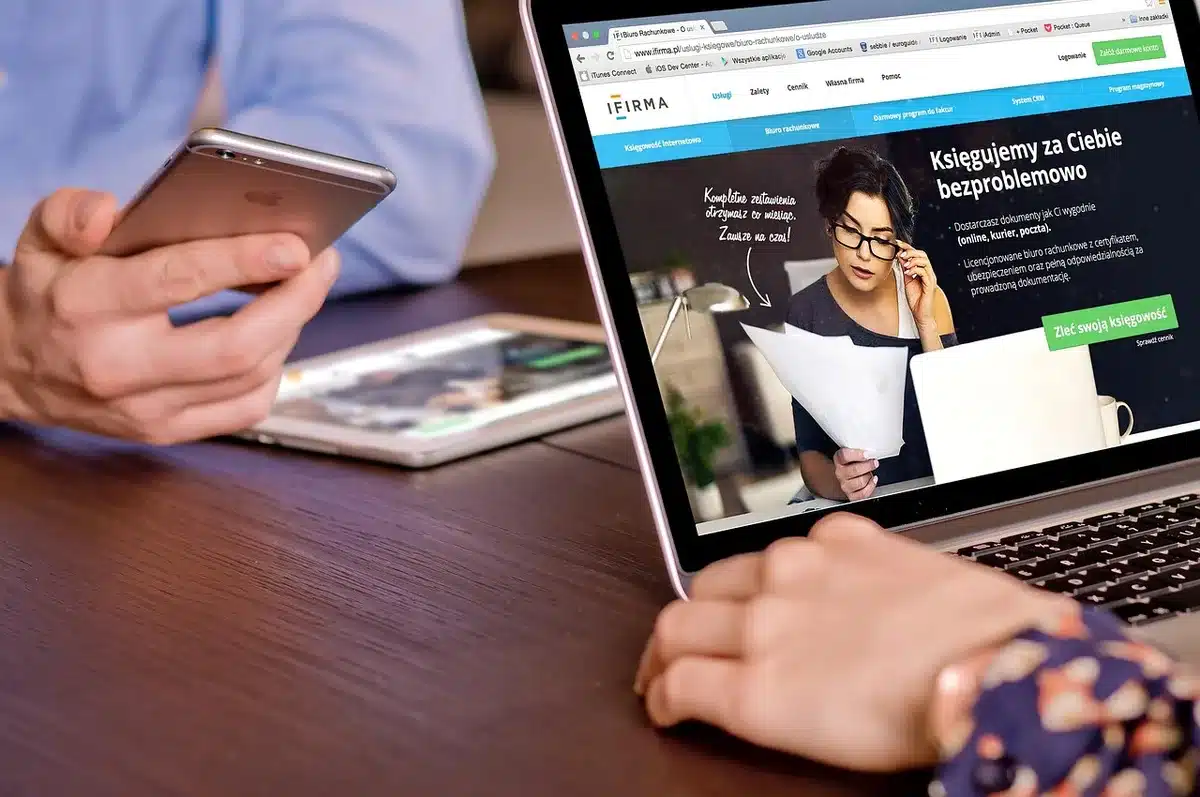 Close-up of an anonymous pair of hands holding an unbranded tablet showing playback controls and a paused video; indoor table background