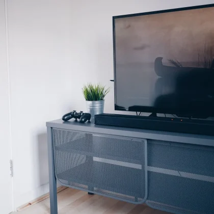 Persona mirando una pantalla con anuncios de videojuegos y tráilers en una sala oscura