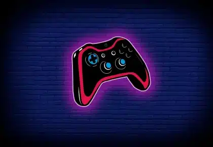 Manos sosteniendo un controlador de videojuegos frente a una pantalla brillante con símbolos de aventura