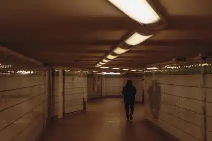 Túnel de metro semiinundado con mochila y rifle apoyados, ambiente postapocalíptico