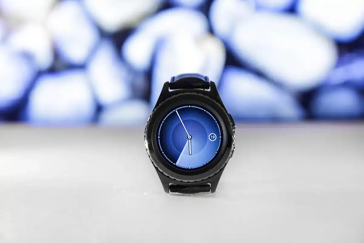 Empty aluminium watch case on a neutral tabletop, no logos, with an unbranded sport strap beside it