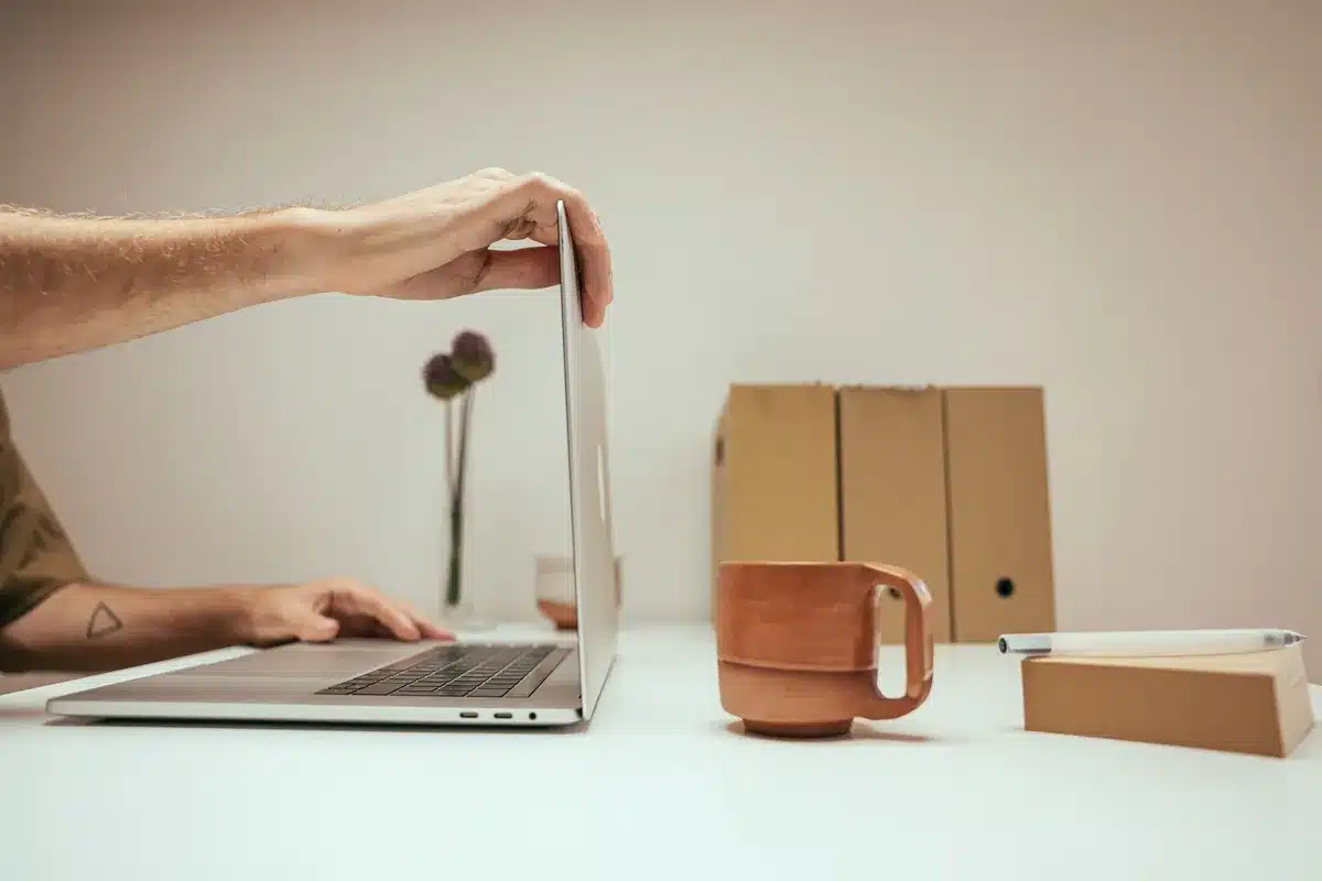 Mesa de trabajo con portátil y carpetas físicas que representan productividad