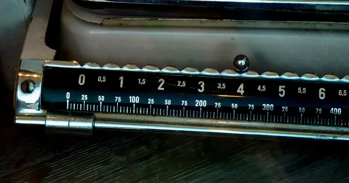 stainless kitchen scale on a wooden counter, close-up of digital display and measuring bowl