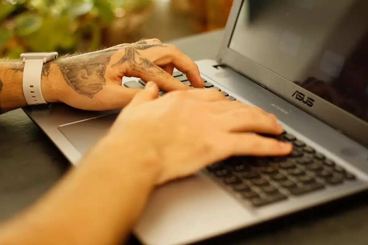 empty laptop keyboard with a power button highlighted on a dark desk, soft natural window light