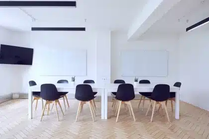 Mesa de reunión con notas y prototipos de juego, silla vacía