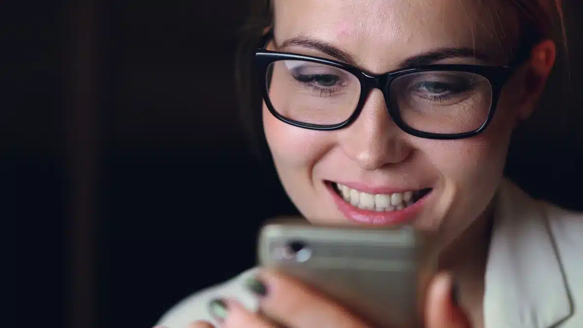 close-up of an anonymous hand scrolling on a smartphone showing a generic chat conversation with short AI replies; no logos or faces