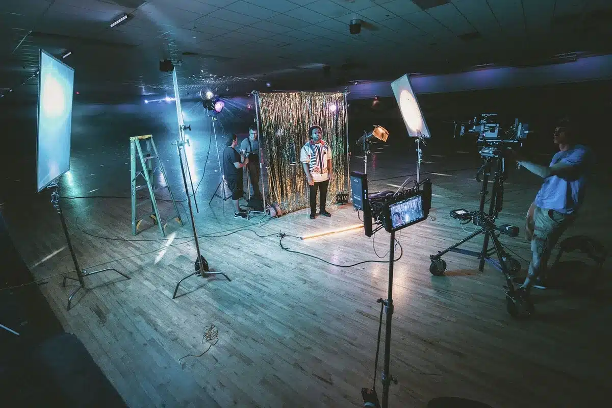 Equipo t&eacute;cnico ajustando luces y c&aacute;maras en un escenario preparado para evento