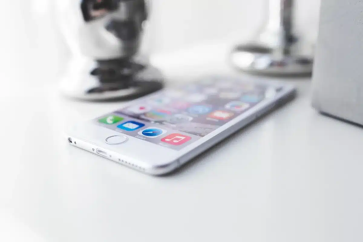A slim anonymous smartphone seen edge-on on a wooden table, thin profile emphasized, no logos or brands