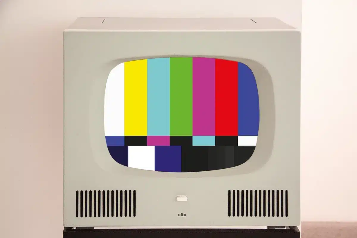 close-up of unbranded TV screen showing vivid color test pattern, no logos, hands-off framing, modern console below