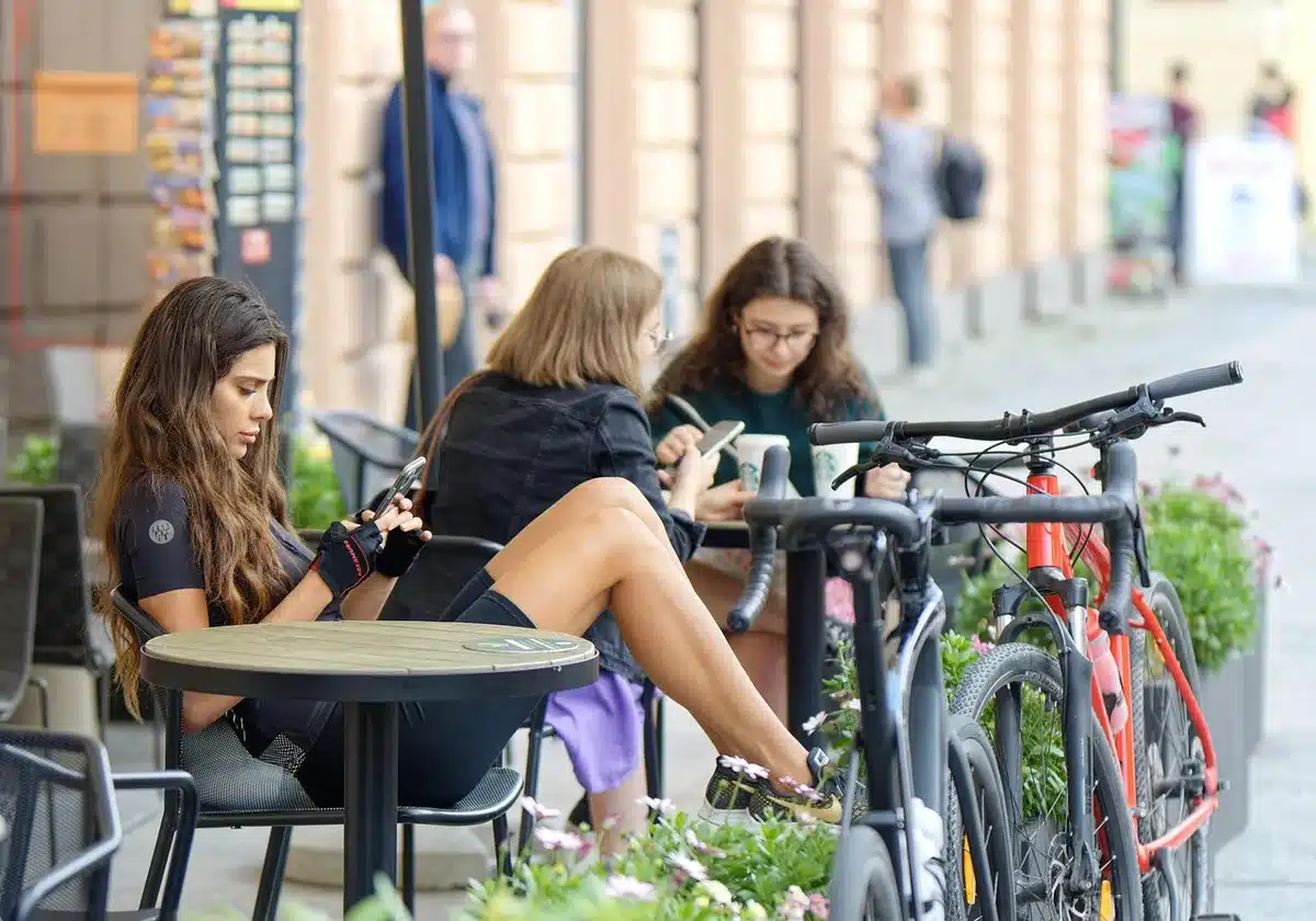 Anonymous group of friends gathered around a table with smartphones, celebrating a fantasy football result, faces unidentifiable