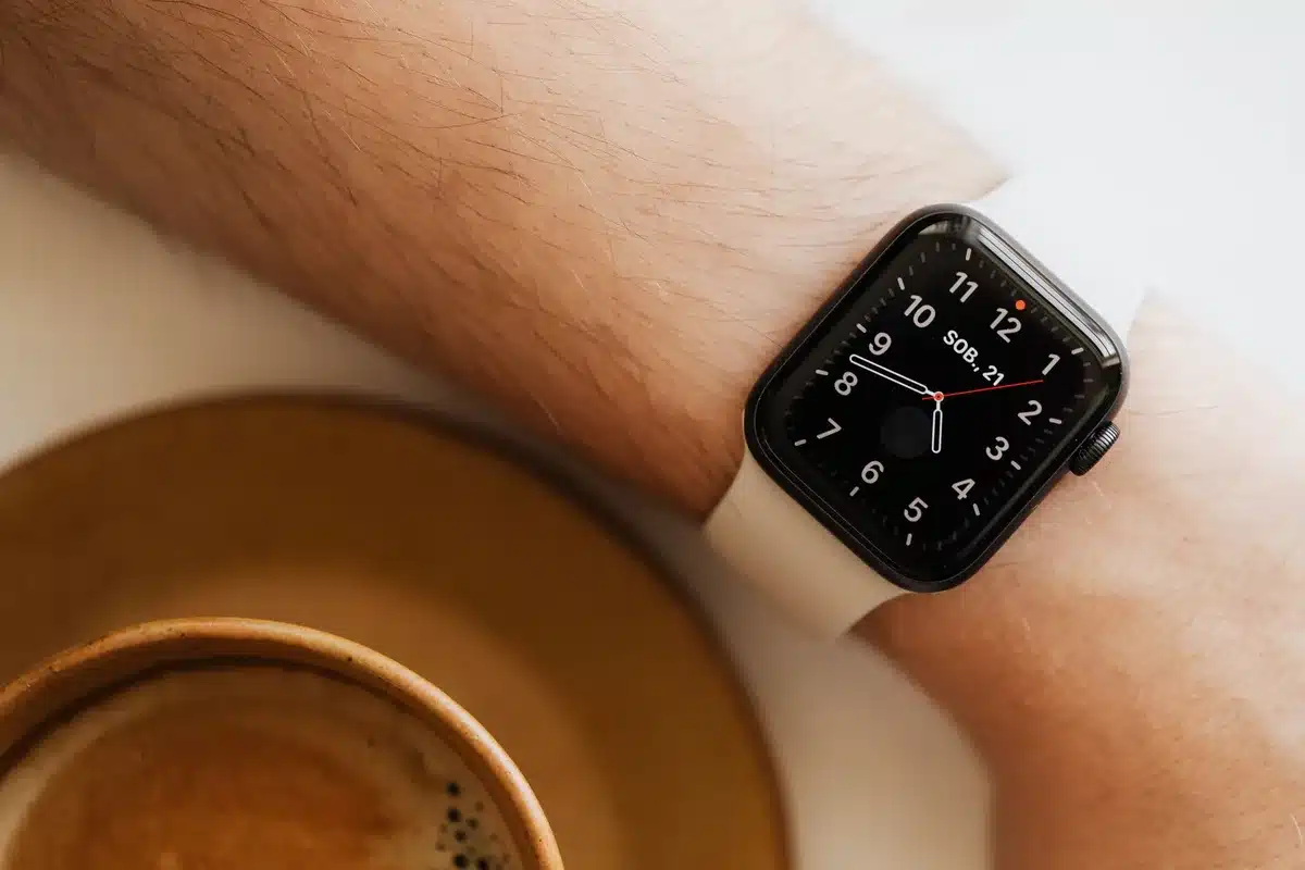 empty smartwatch display on a wooden table with a band beside it, soft natural light