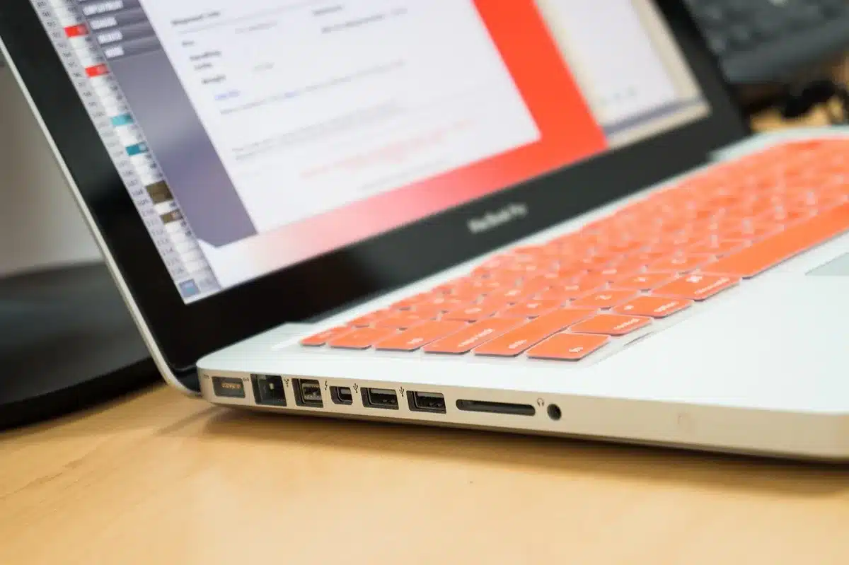 Mano anónima conectando un pendrive a un portátil sobre un escritorio