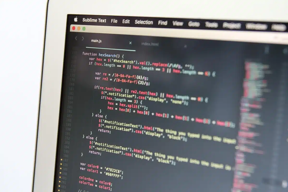 Close-up of anonymous hands typing on a laptop keyboard beside a notebook, implying developer work on integrations