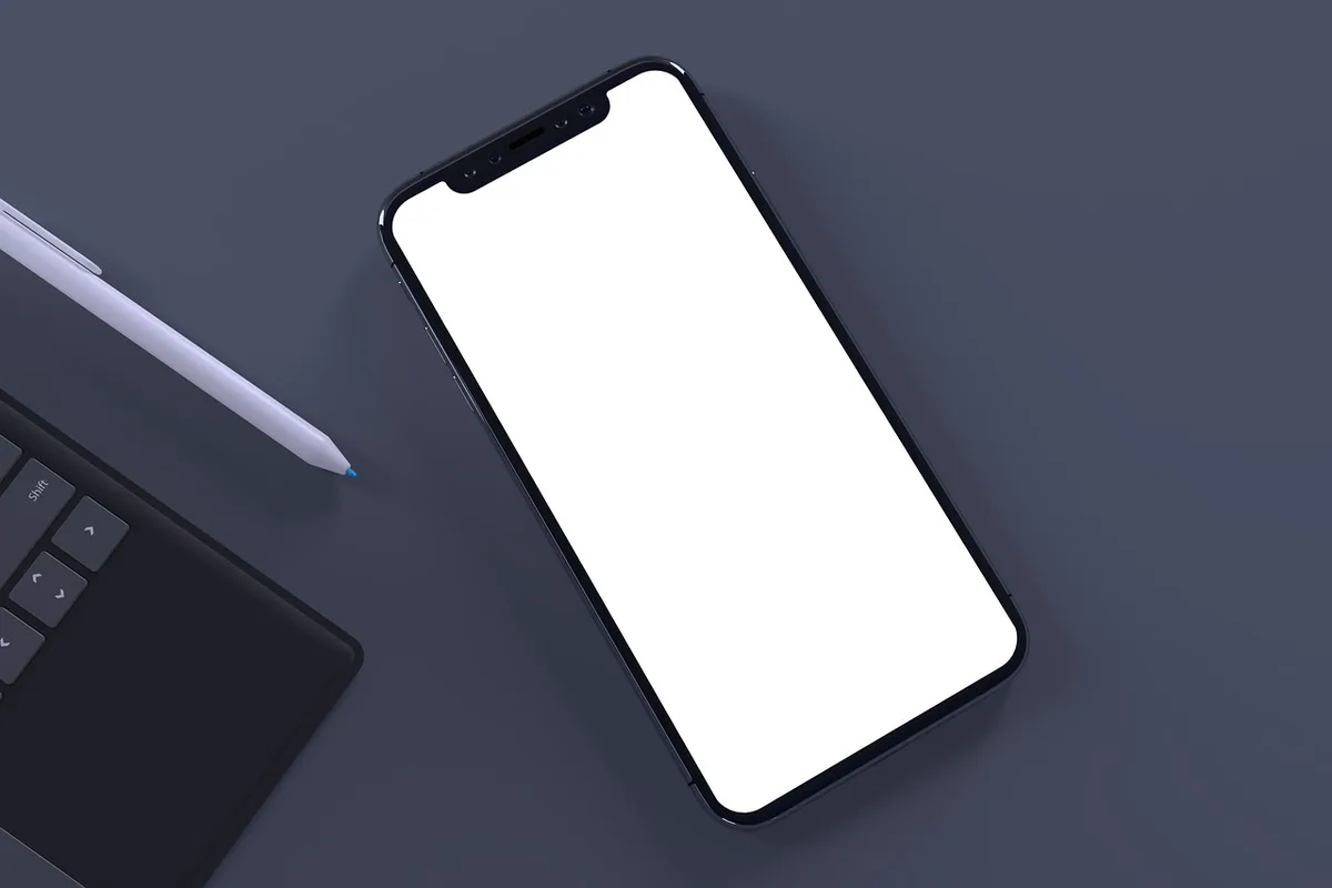 Close-up of an unbranded smartphone lying on a desk next to a USB-C cable, screen off, matte finish, no logos visible