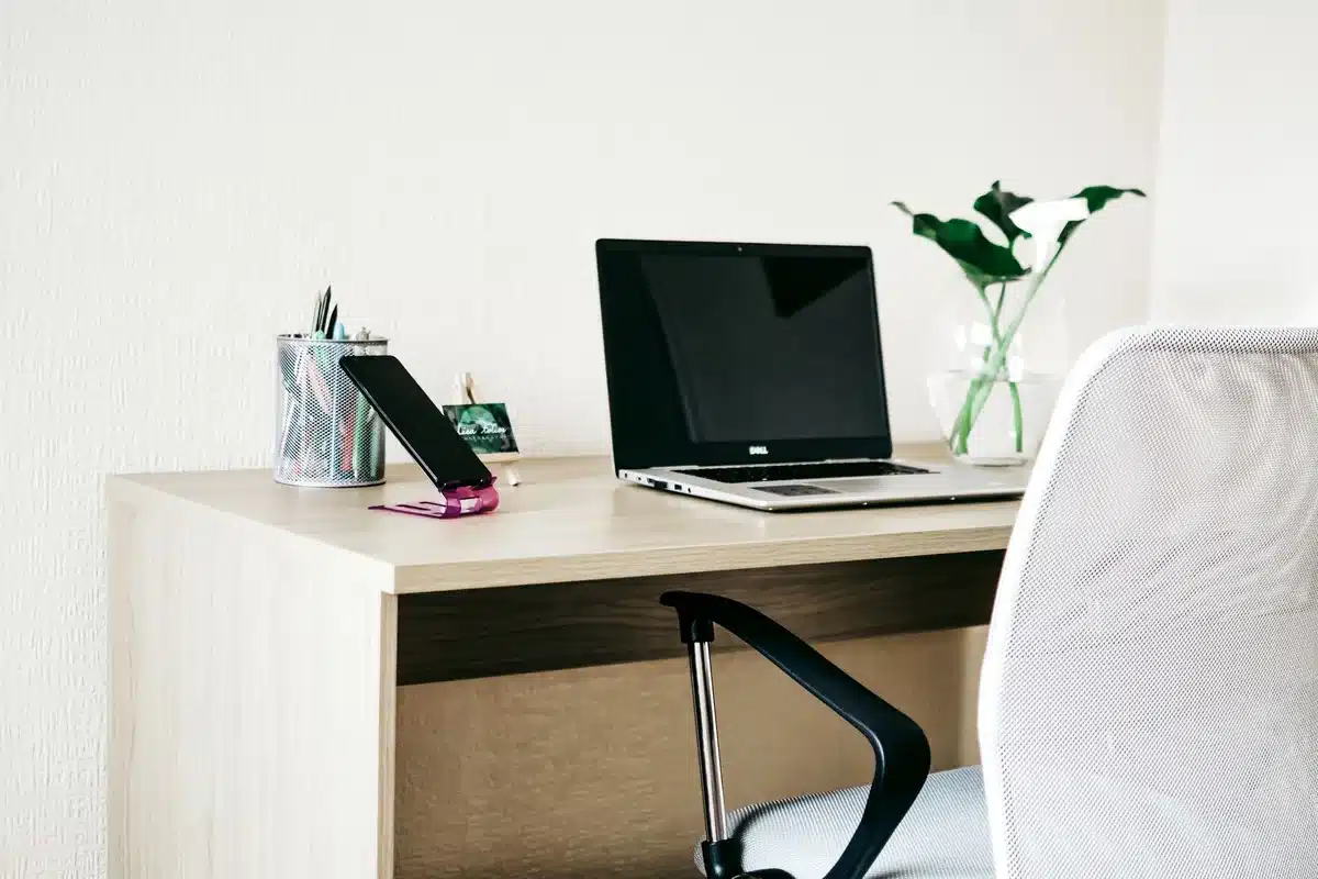 Empty modern smartphone on a desk with a glowing screen and a small folded device beside it, no logos or text