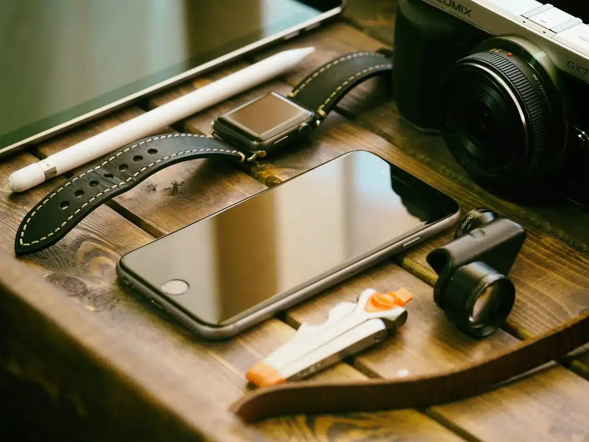 Anonymous workspace with an unbranded phone on a desk, open camera app interface showing subject-tracking overlay, no faces or logos