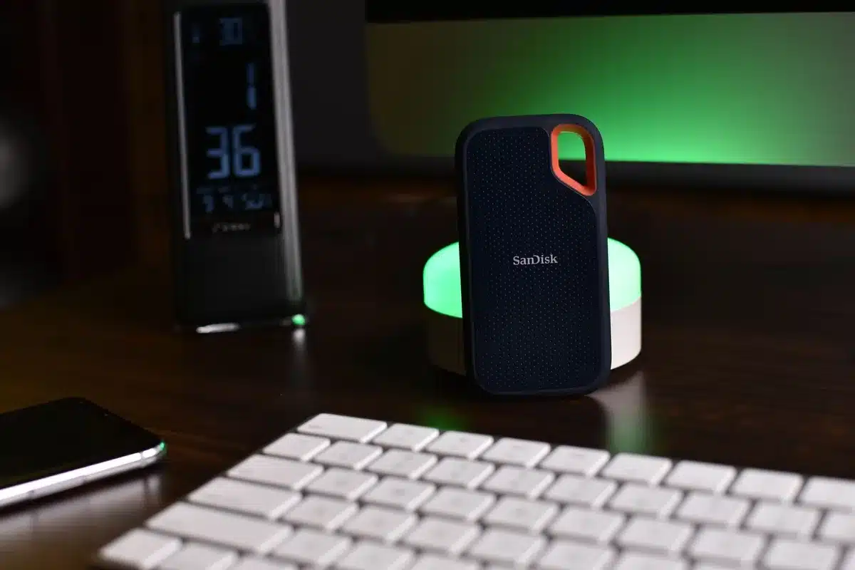 A tidy desktop with an external SSD beside a closed laptop, anonymous environment, product boxes stacked neatly, sale tags implied but unreadable