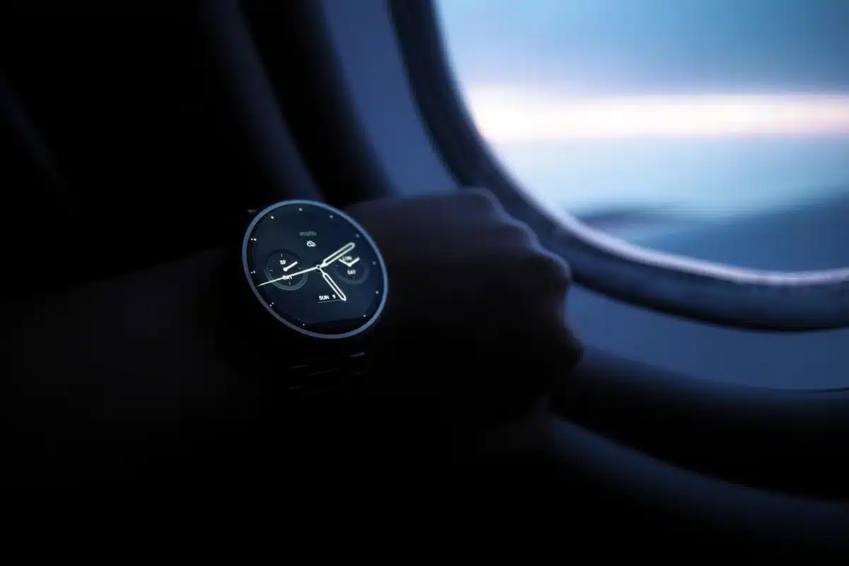 anonymous runner pausing on a rocky path looking at an unbranded smartwatch screen
