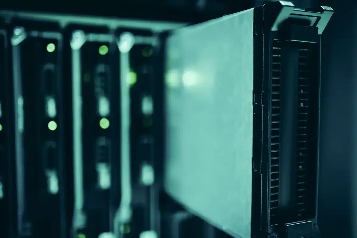 An empty server rack corridor lit by cool LEDs, a single rack door ajar and a loose network cable on the floor suggesting urgent maintenance