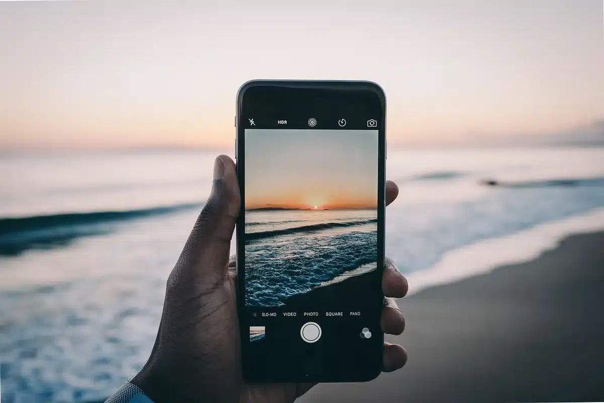 anonymous hands holding an unbranded phone showing camera app UI and zoomed photo preview