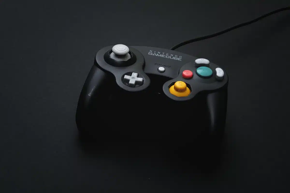 Anonymous hands holding a PS5 controller silhouetted against a screen showing a system update prompt, blurred room