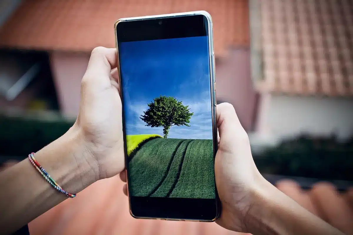 anonymous hands holding a phone showing fast-charging animation, cable connected but no brand visible, blurred background of a living room