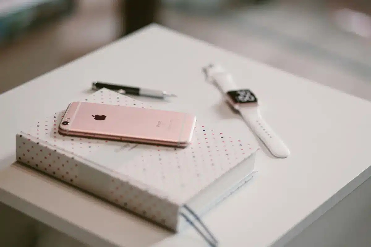 A generic unbranded smartwatch on a small tabletop near a shopping receipt and a smartphone, no logos, clear daylight macro