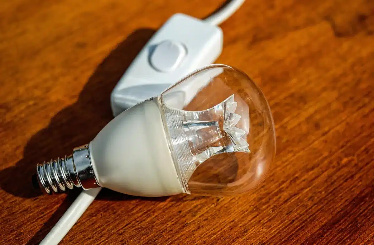 empty router LED lights in a dark corner, blurred cables and a faint laptop screen glow