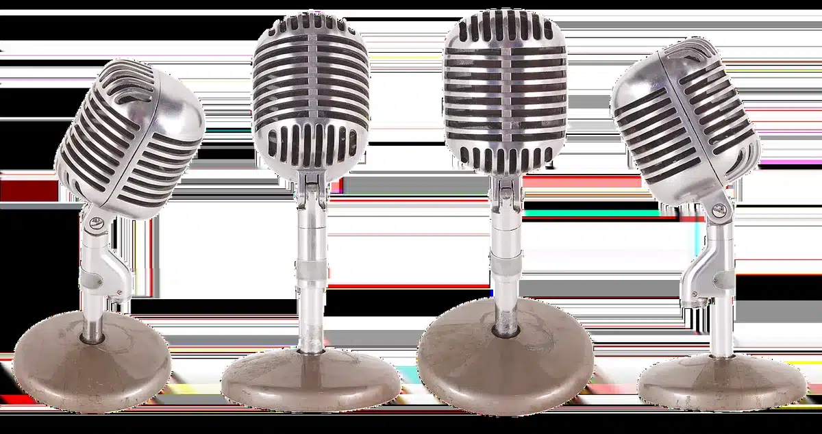 Empty stage with a single vintage microphone under a spotlight, dust motes visible and the room otherwise dark