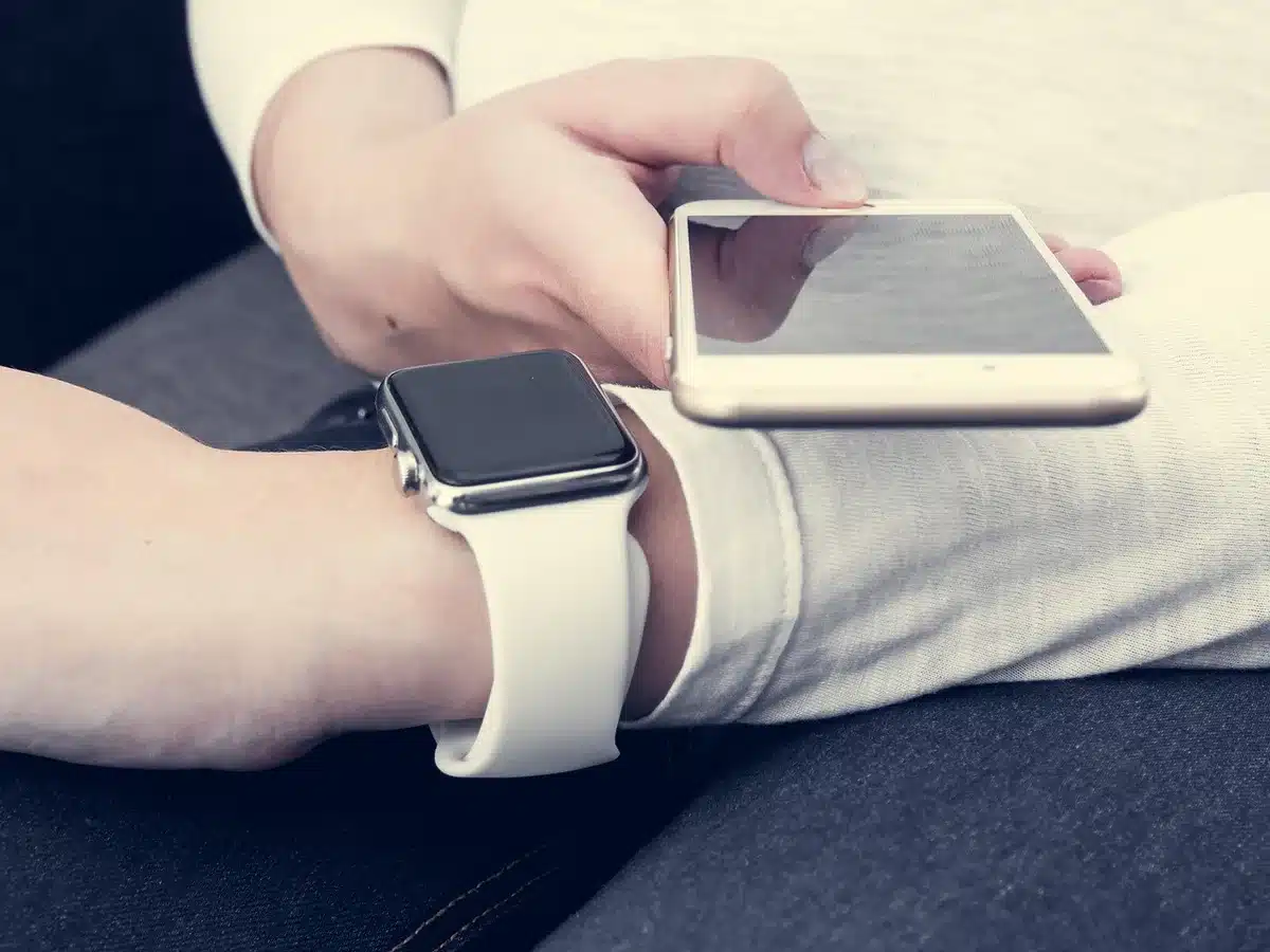 An anonymous rugged smartwatch on a neutral pedestal, titanium case and perforated silicone strap visible, no logos or text