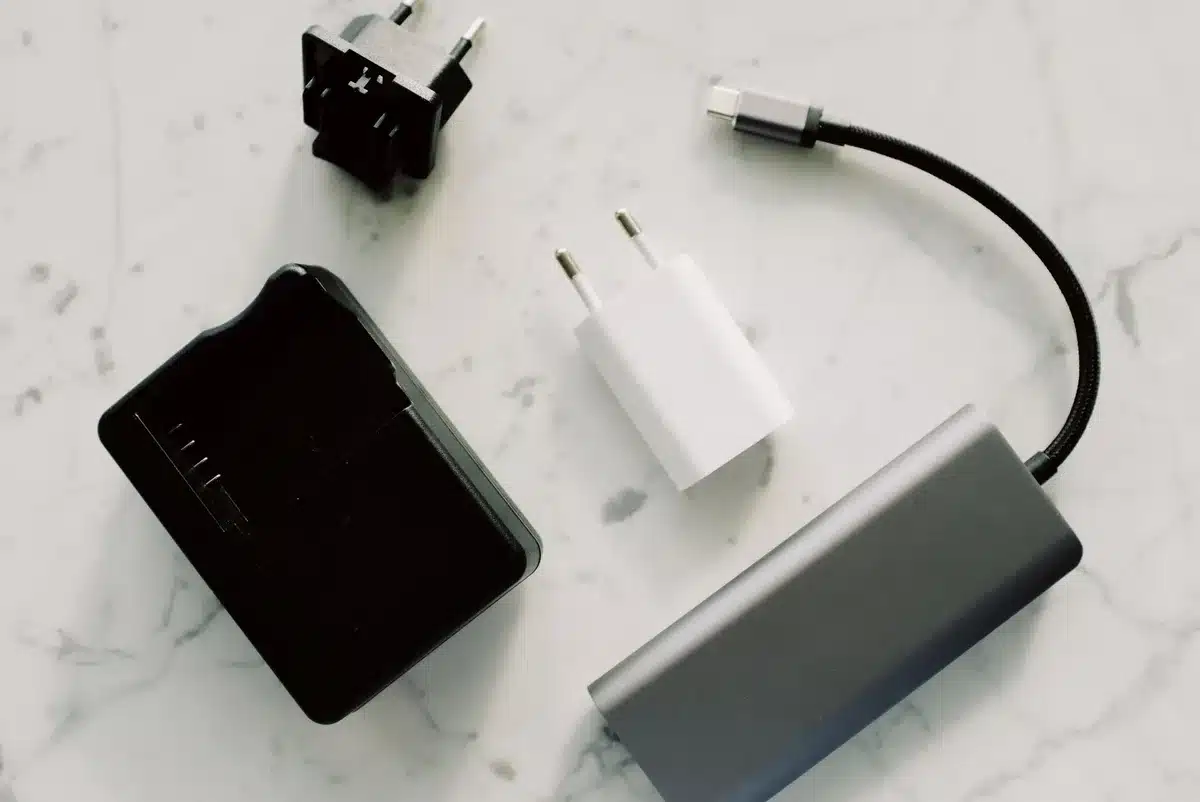 Close-up of an unbranded portable power bank with a small digital display and a visible liquid cooling chamber, placed on a wooden table