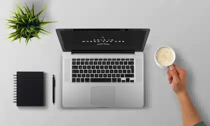 Mano junto a un teclado y barra de desplazamiento en pantalla, vista anónima