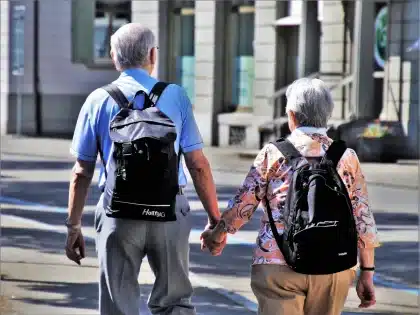 Controlador compacto y smartphone sobre una mochila, vista de manos en sombra