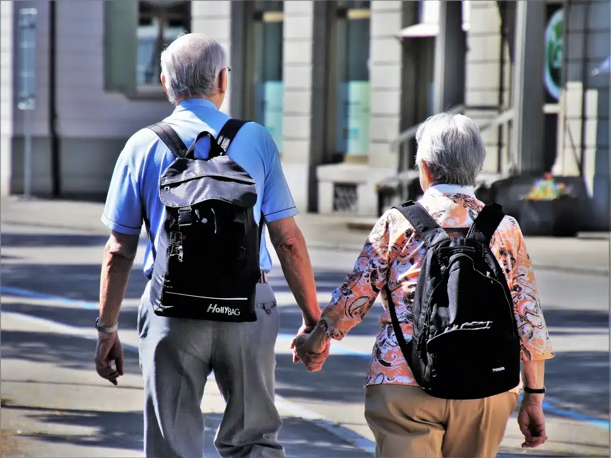 Controlador compacto y smartphone sobre una mochila, vista de manos en sombra