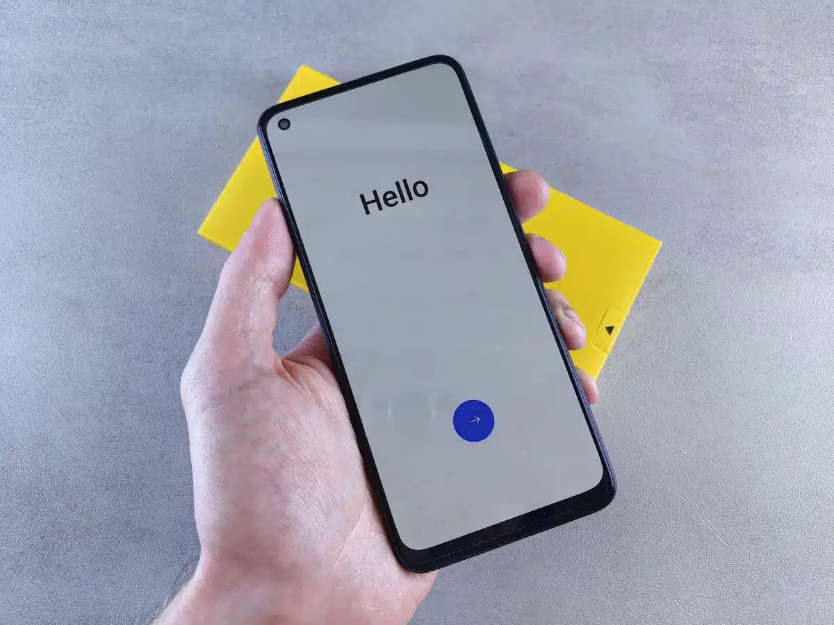 Close-up of an unbranded smartphone box on a plain table, shipping label and a small invoice beside it, no logos visible