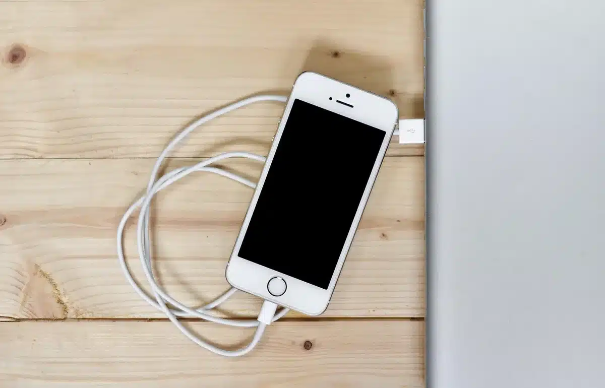 Three anonymous smartphones placed on a plain table with a small label listing battery capacity; no logos or faces, a neutral retail-still life that implies endurance and value